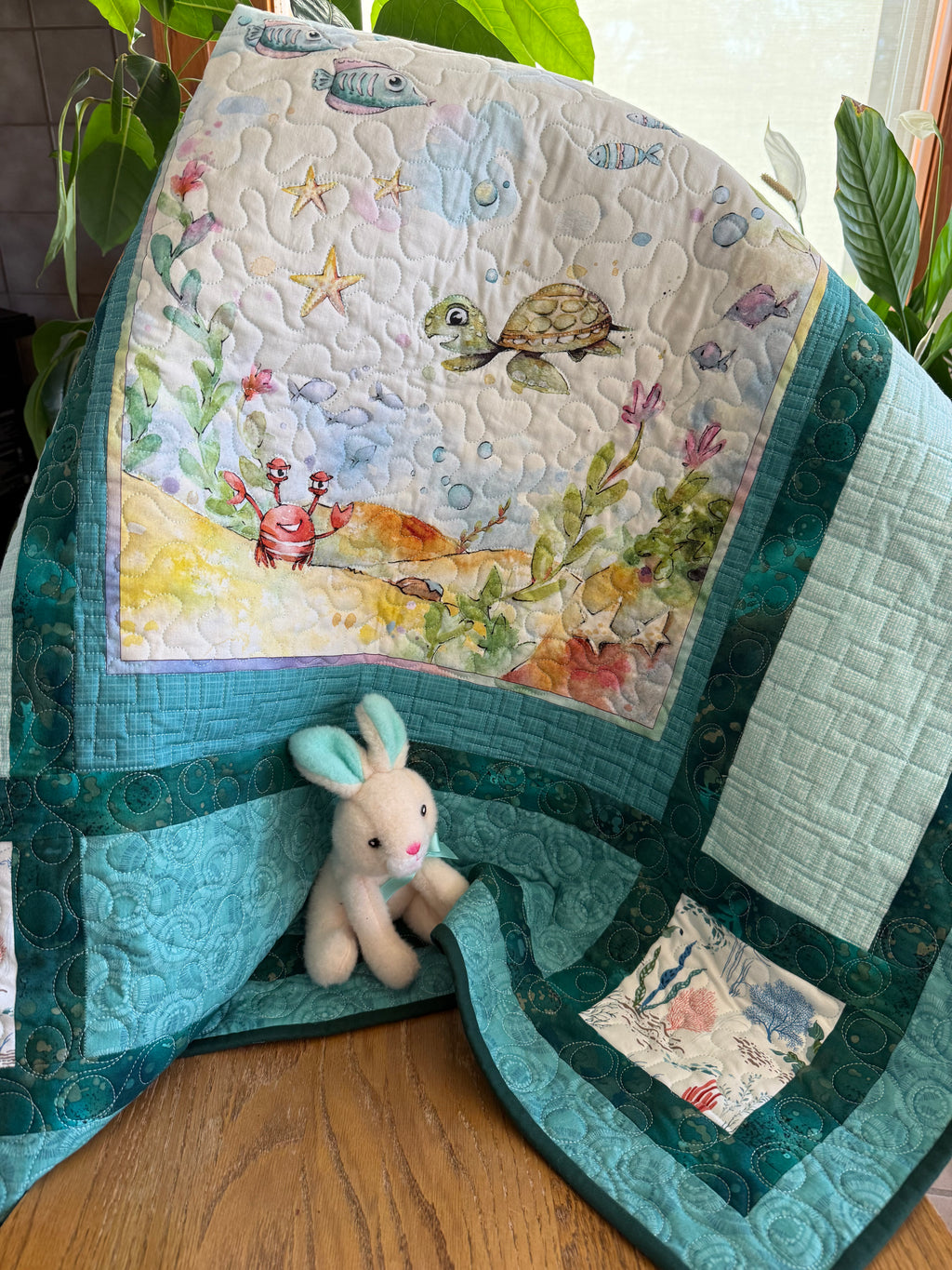 Handmade baby quilt with colorful sea life panel in blues and greens