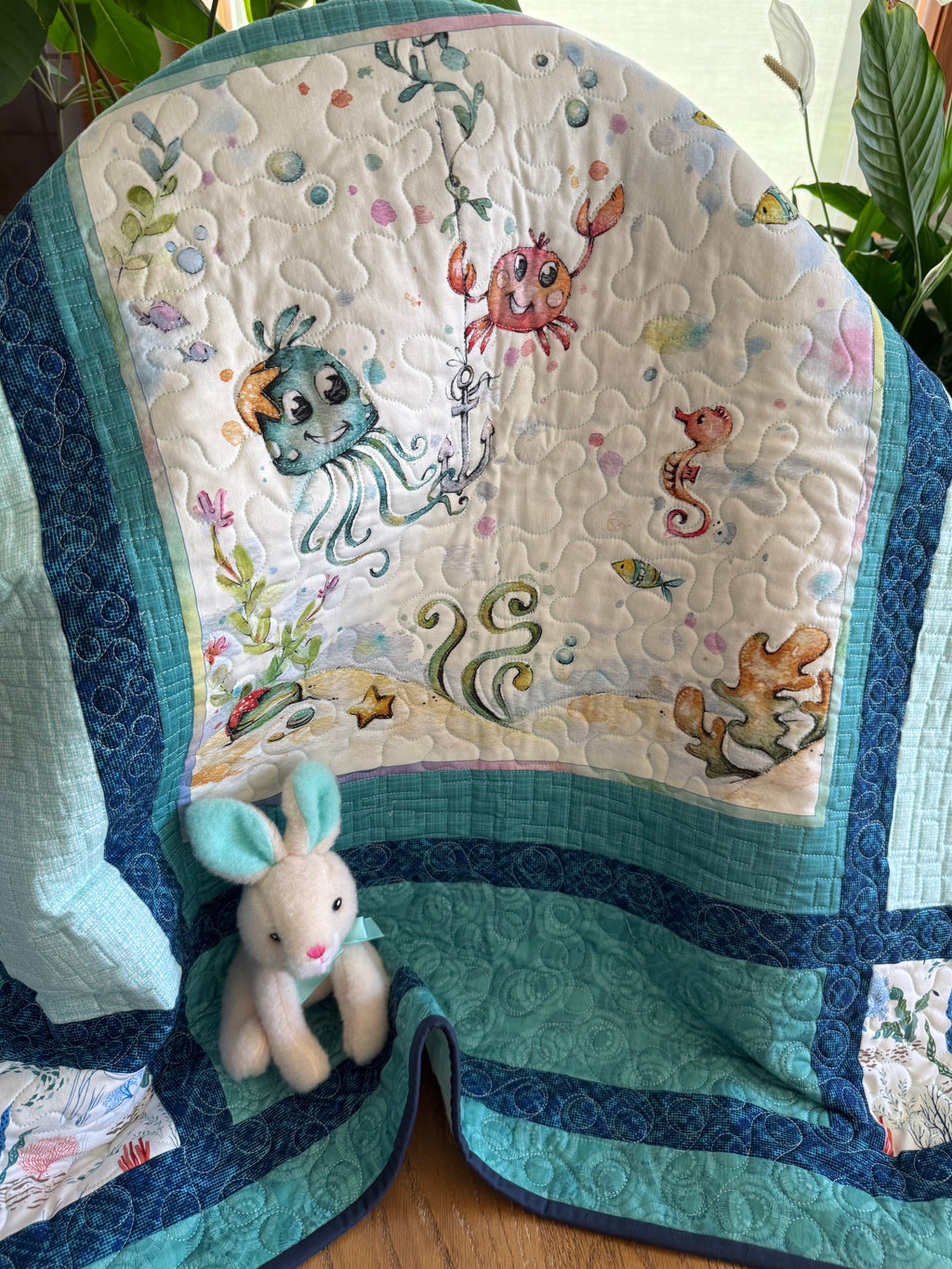 Handmade baby quilt with colorful ocean animals in blues and greens