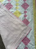 Handmade pink and yellow baby quilt in soft cotton, perfect baby gift, by Oak & Thread Quilts.  Backing is a soft pink fleece