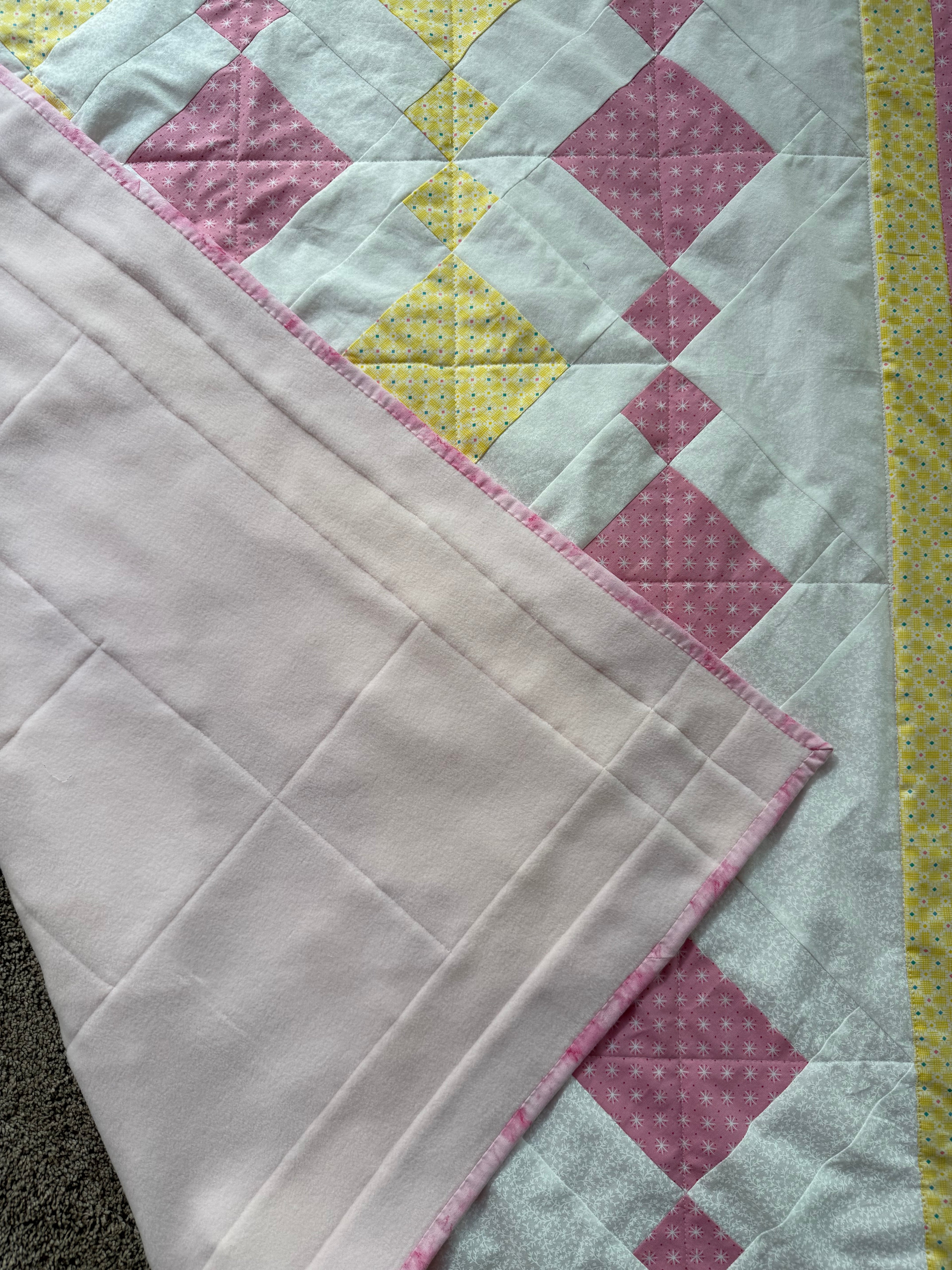 Handmade pink and yellow baby quilt in soft cotton, perfect baby gift, by Oak & Thread Quilts.  Backing is a soft pink fleece