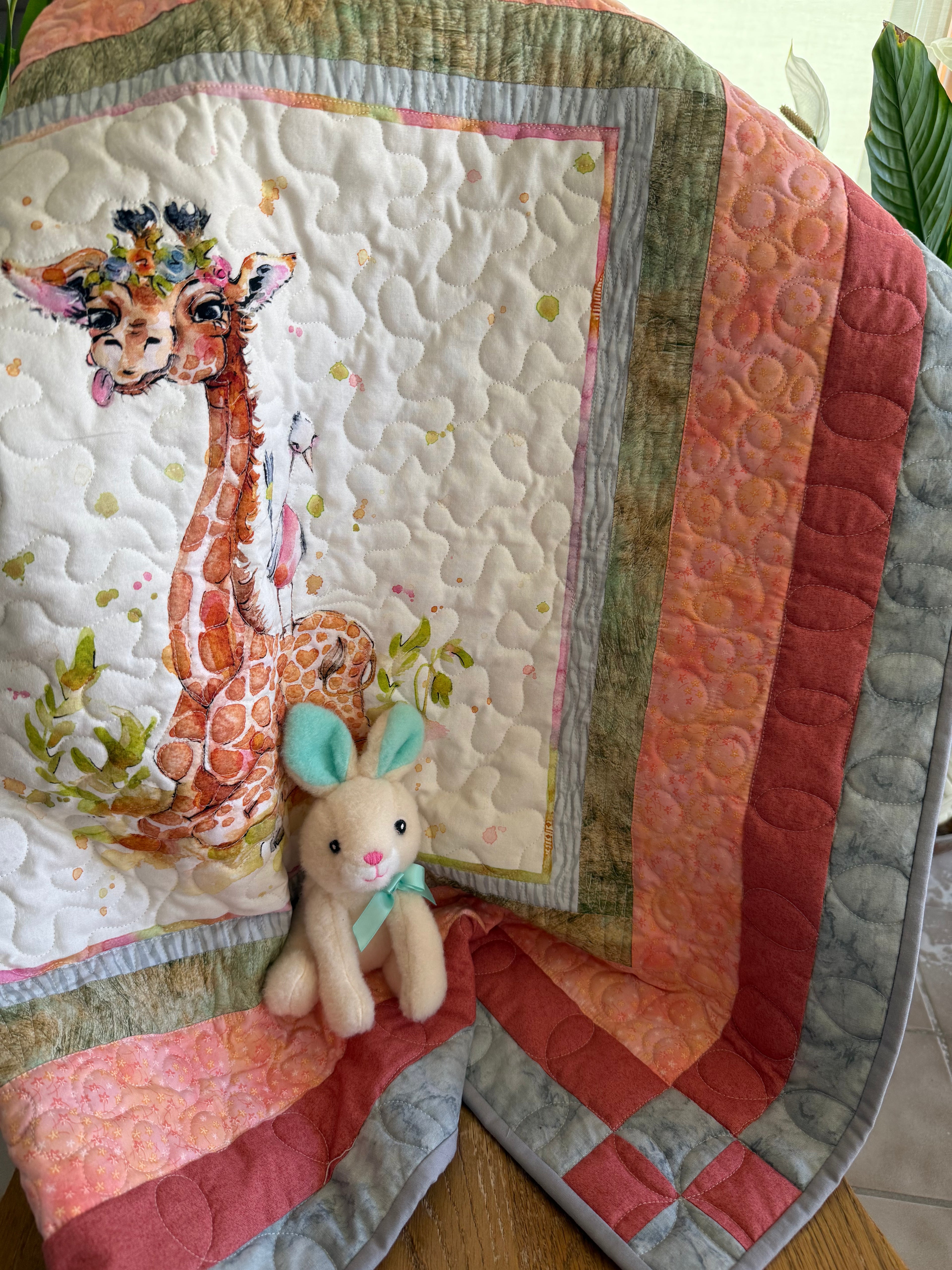 Handmade baby quilt with a giraffe in orange, red and gray