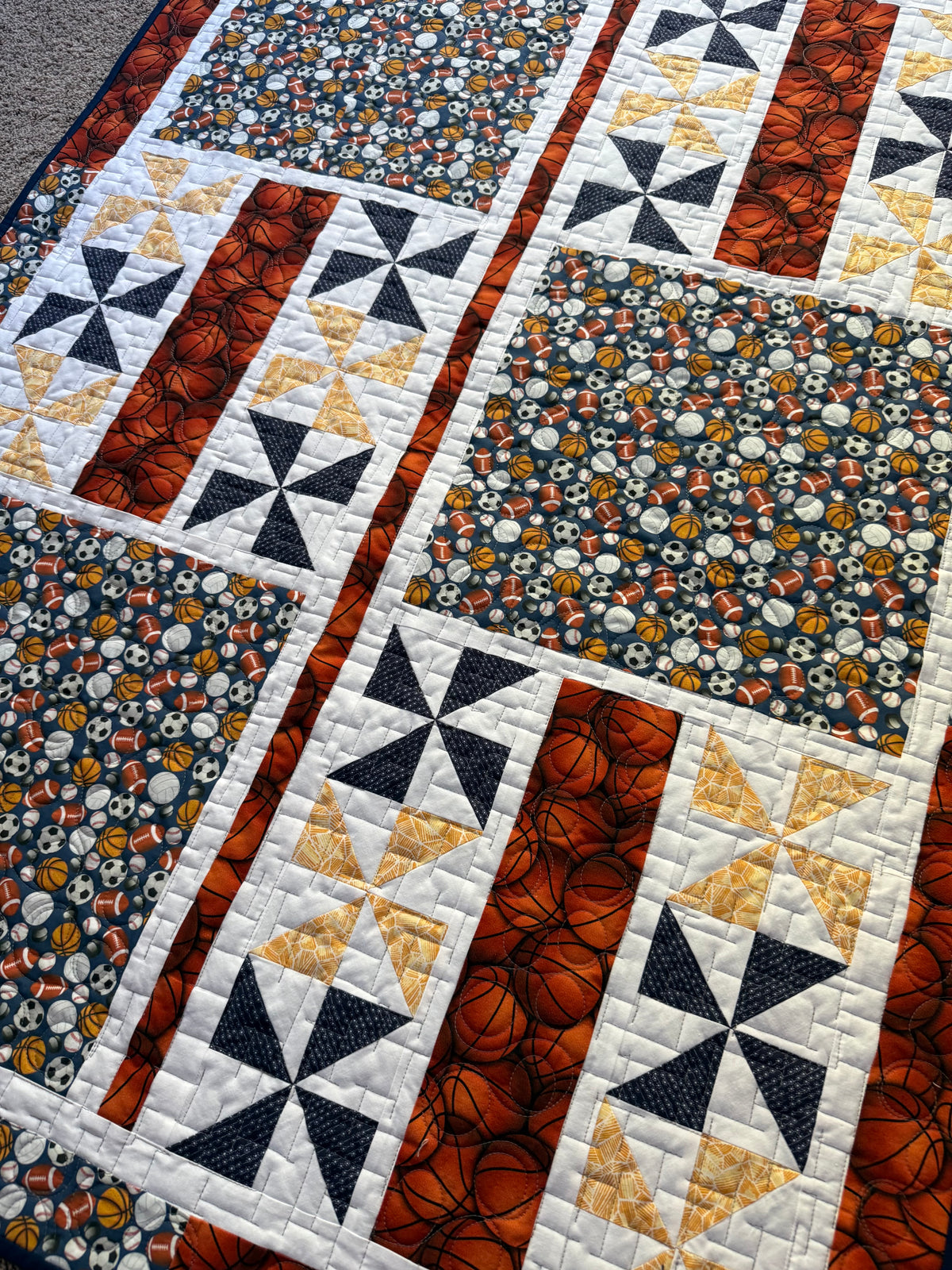 Handmade quilt showing close up of fabric with various balls for sports