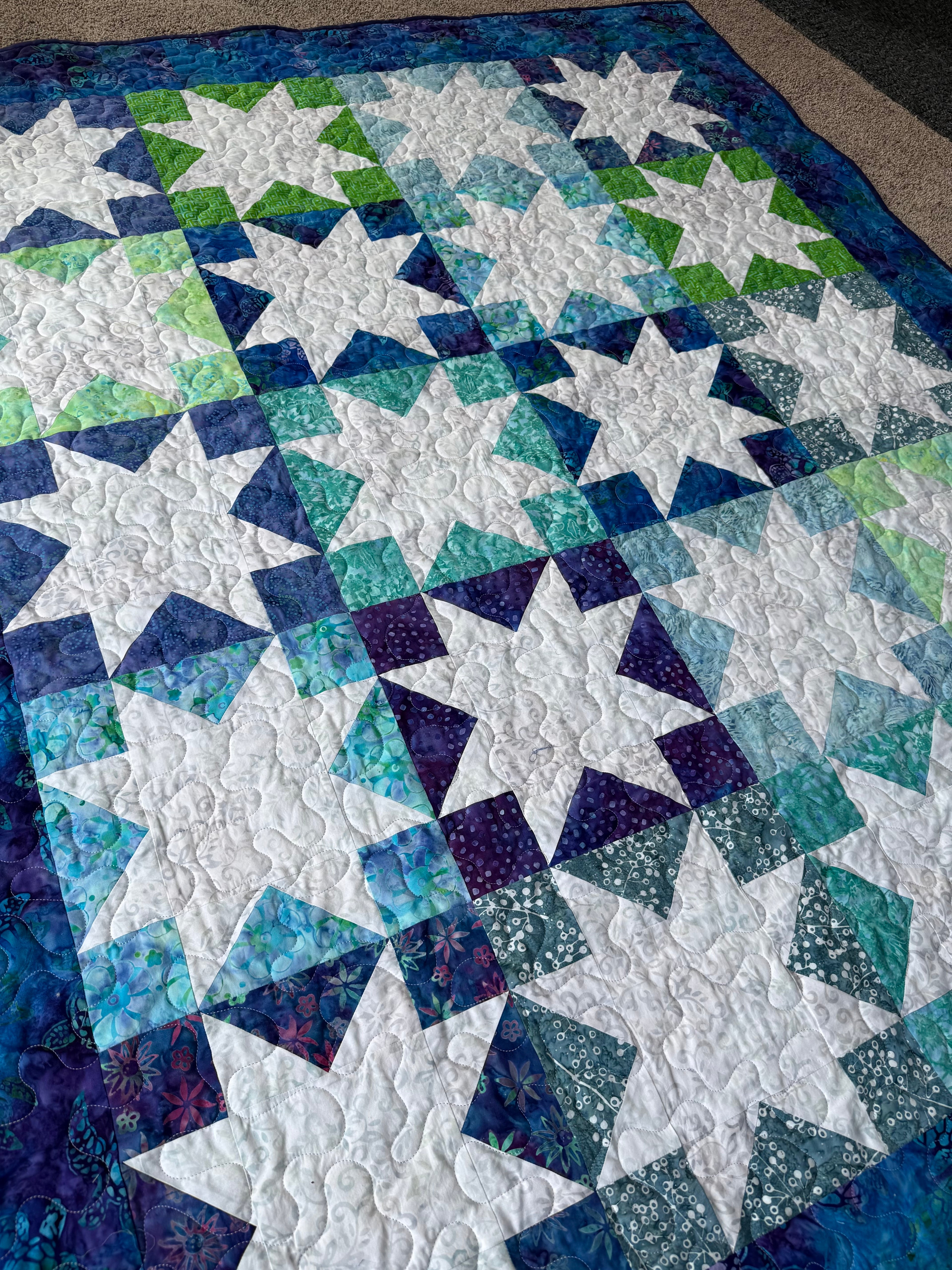 Handmade sea turtle batik quilt laid flat showing full patchwork design