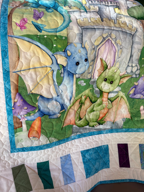 Handmade baby dragon quilt with colorful dragon design, soft cotton fabric, made by Oak & Thread Quilts.  Creative quilting and colorful border is shown