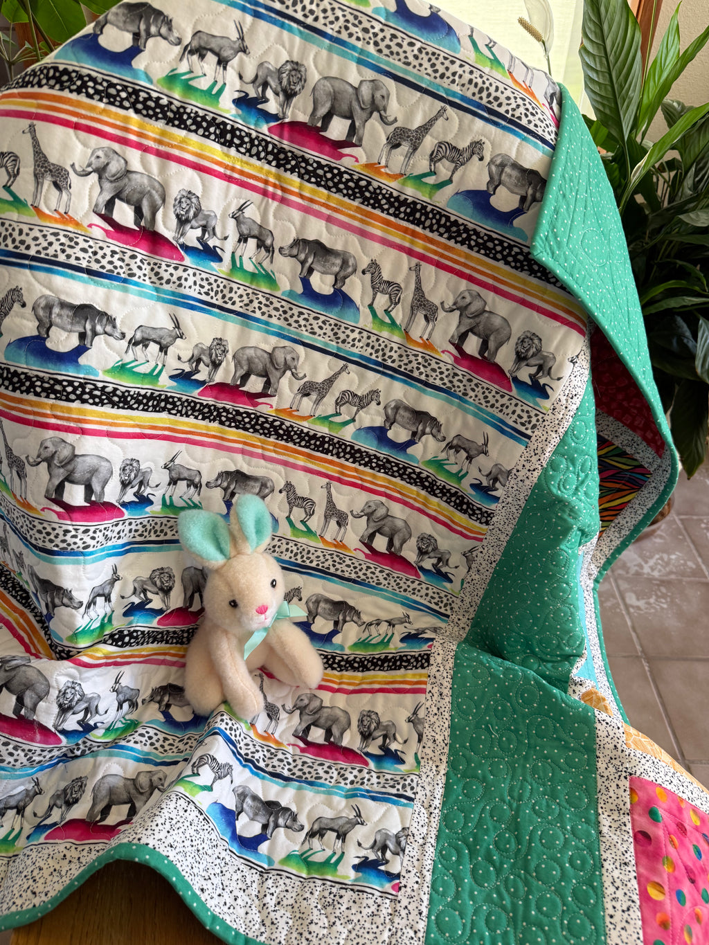 Colorful handmade quilt with safari animals and green dotted fabric