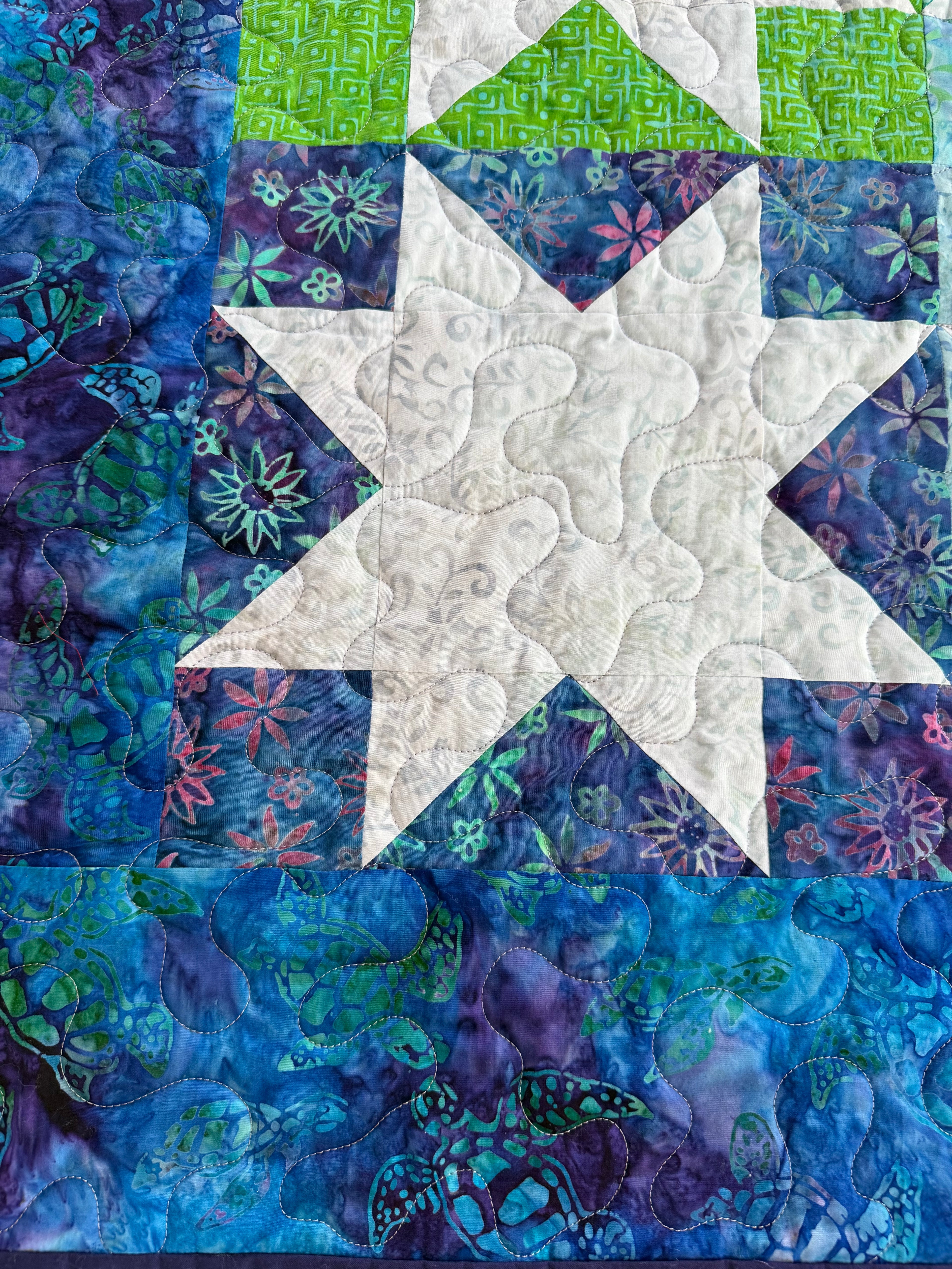 Sea turtle quilt corner showing quilting stitches and binding"