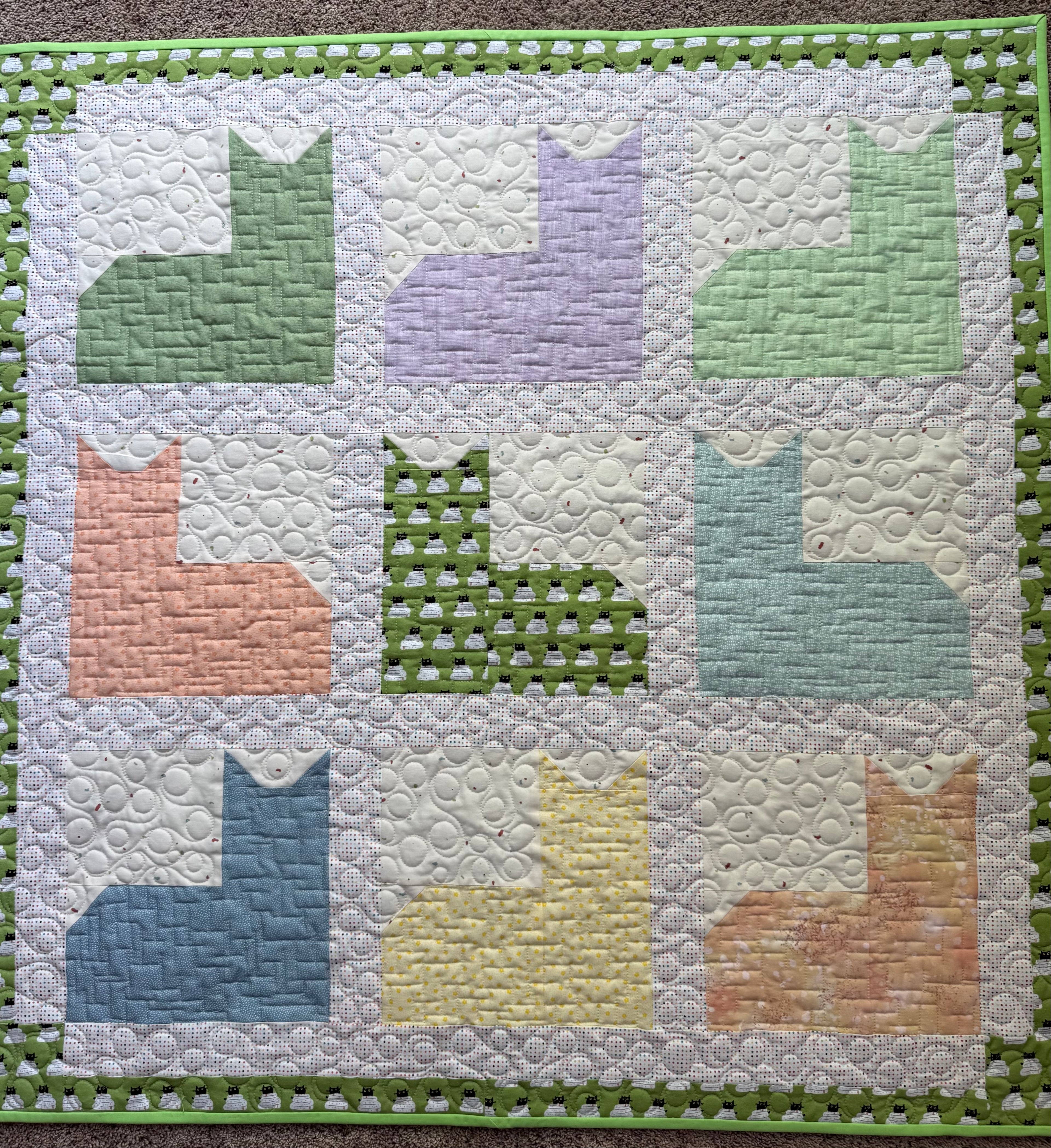 Handmade cat quilt in various pastel colors