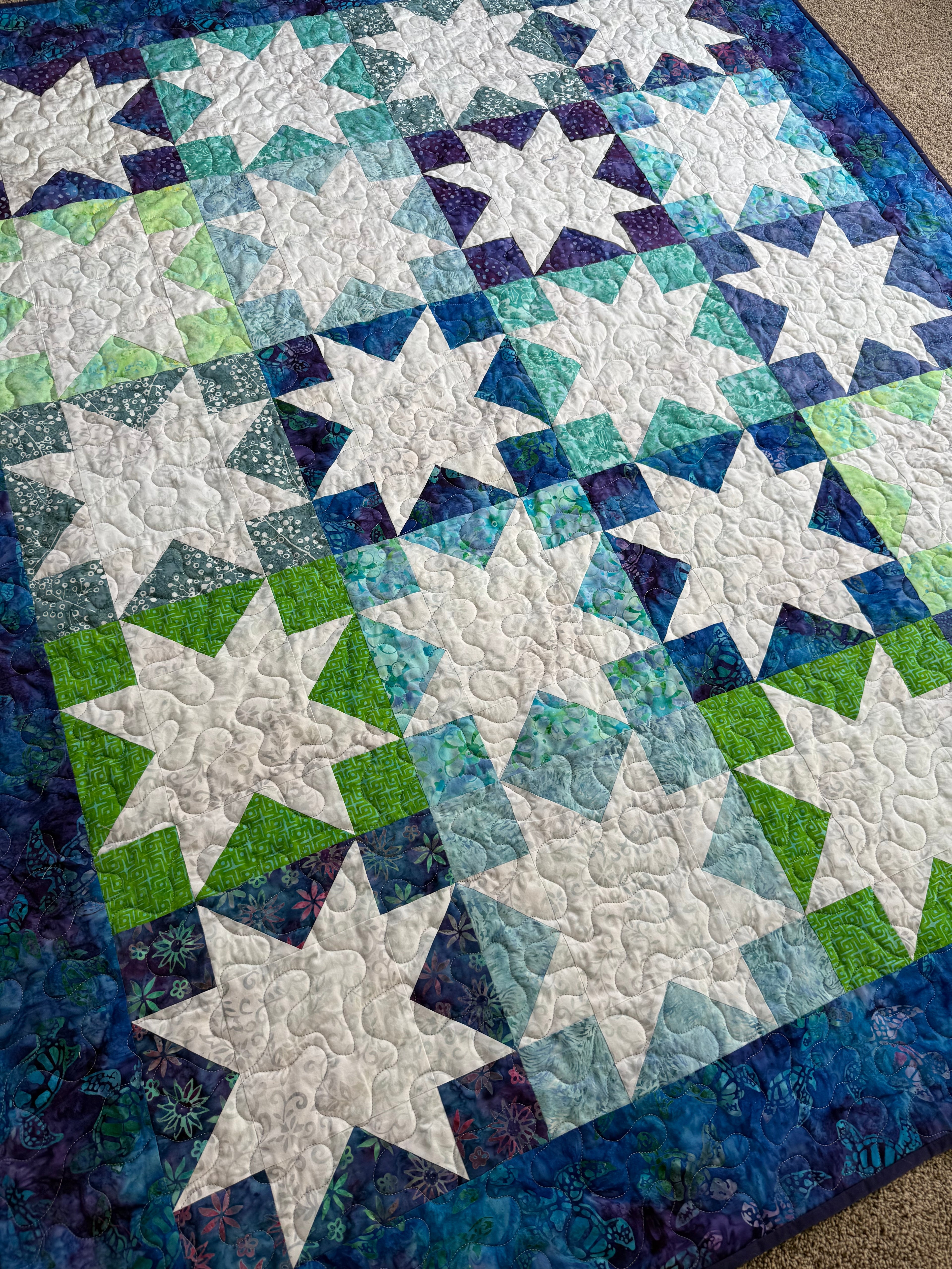 Detail shot of batik sea turtle fabric squares in patchwork quilt