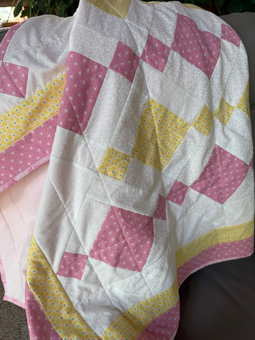 Handmade pink and yellow baby quilt in soft cotton, perfect baby gift, by Oak & Thread Quilts.  No batting, just patchwork top and fleece backing