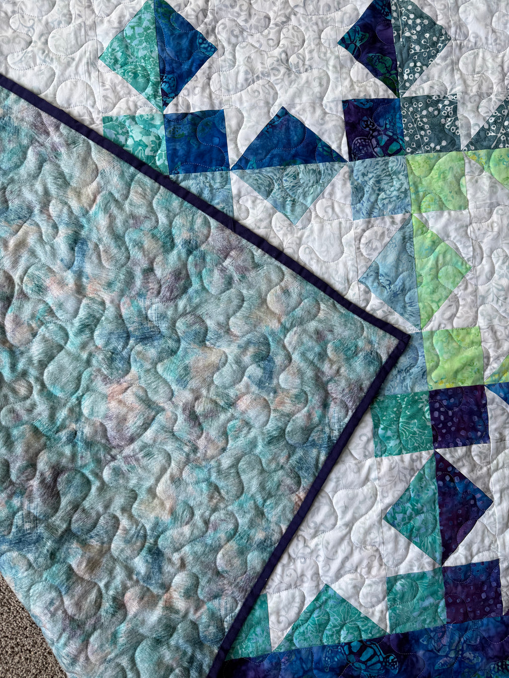 Sea turtle batik quilt folded to show texture and backing"