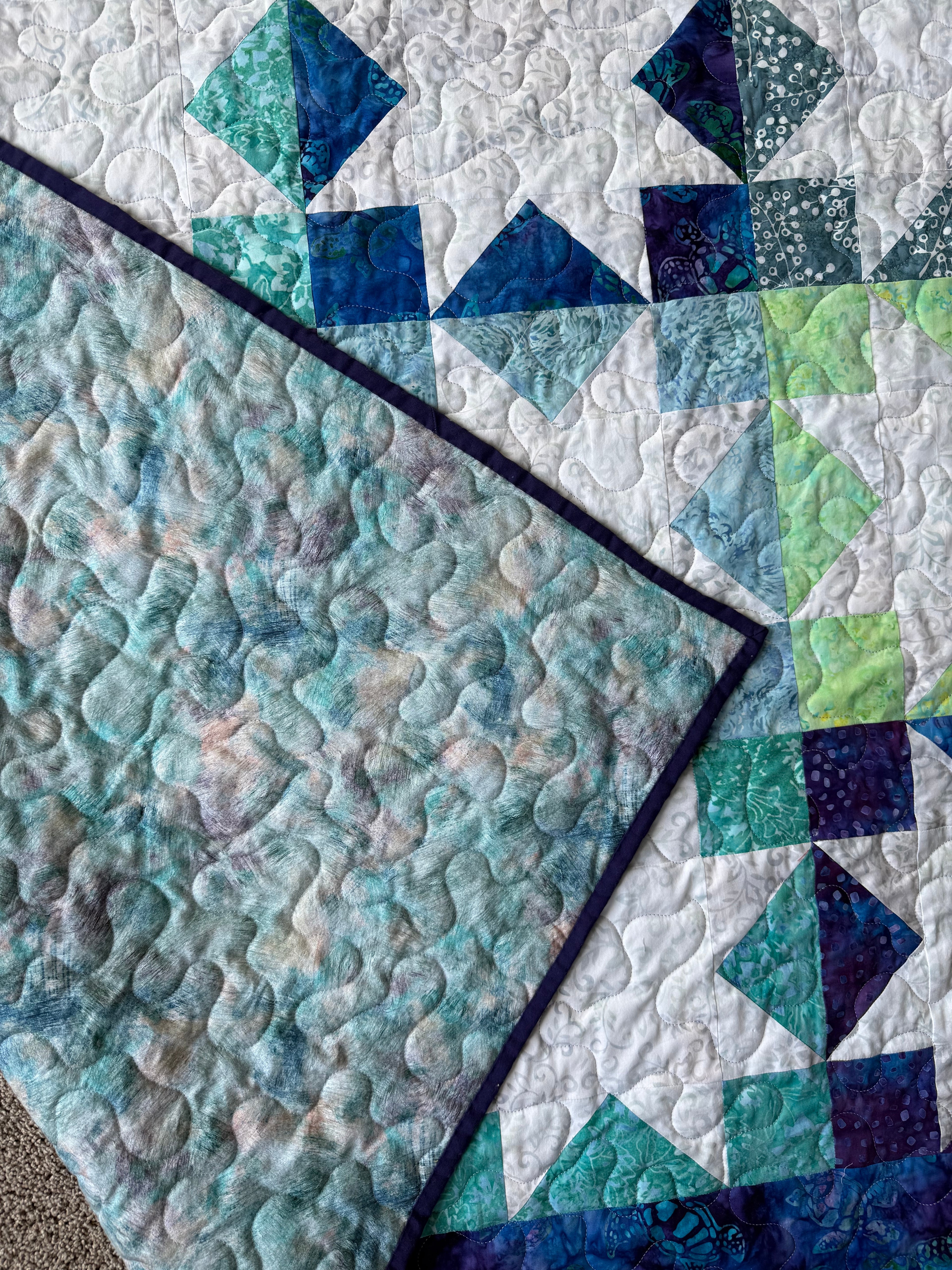 Sea turtle batik quilt folded to show texture and backing"