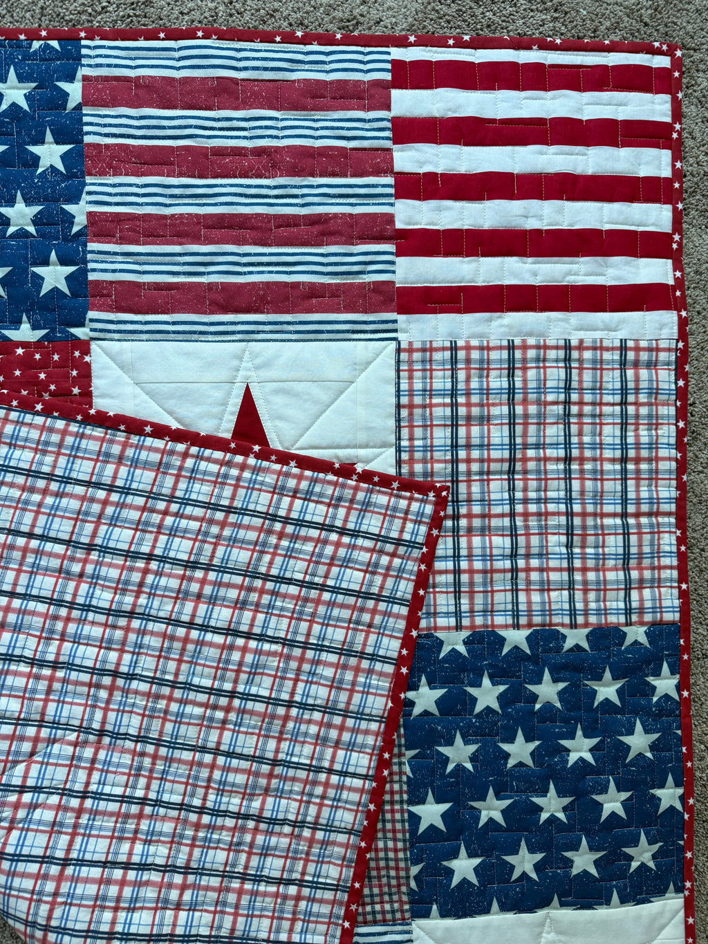 Handmade quilt showing red, white, and blue plaid backing