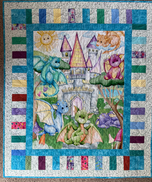 Handmade colorful baby dragon quilt with pieced border and teal background