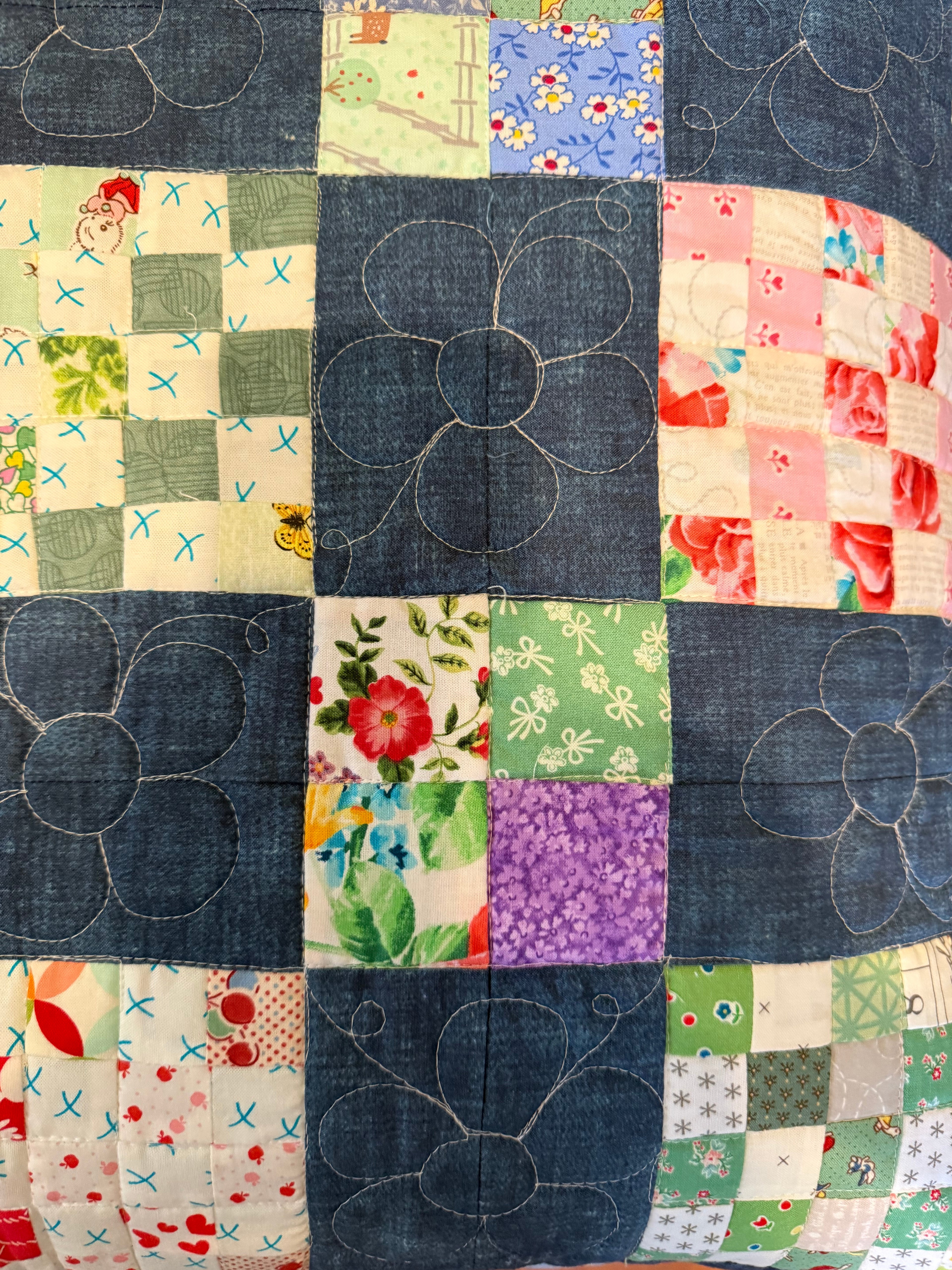 Close-up of checkerboard fabric squares in handmade throw quilt showing quilting