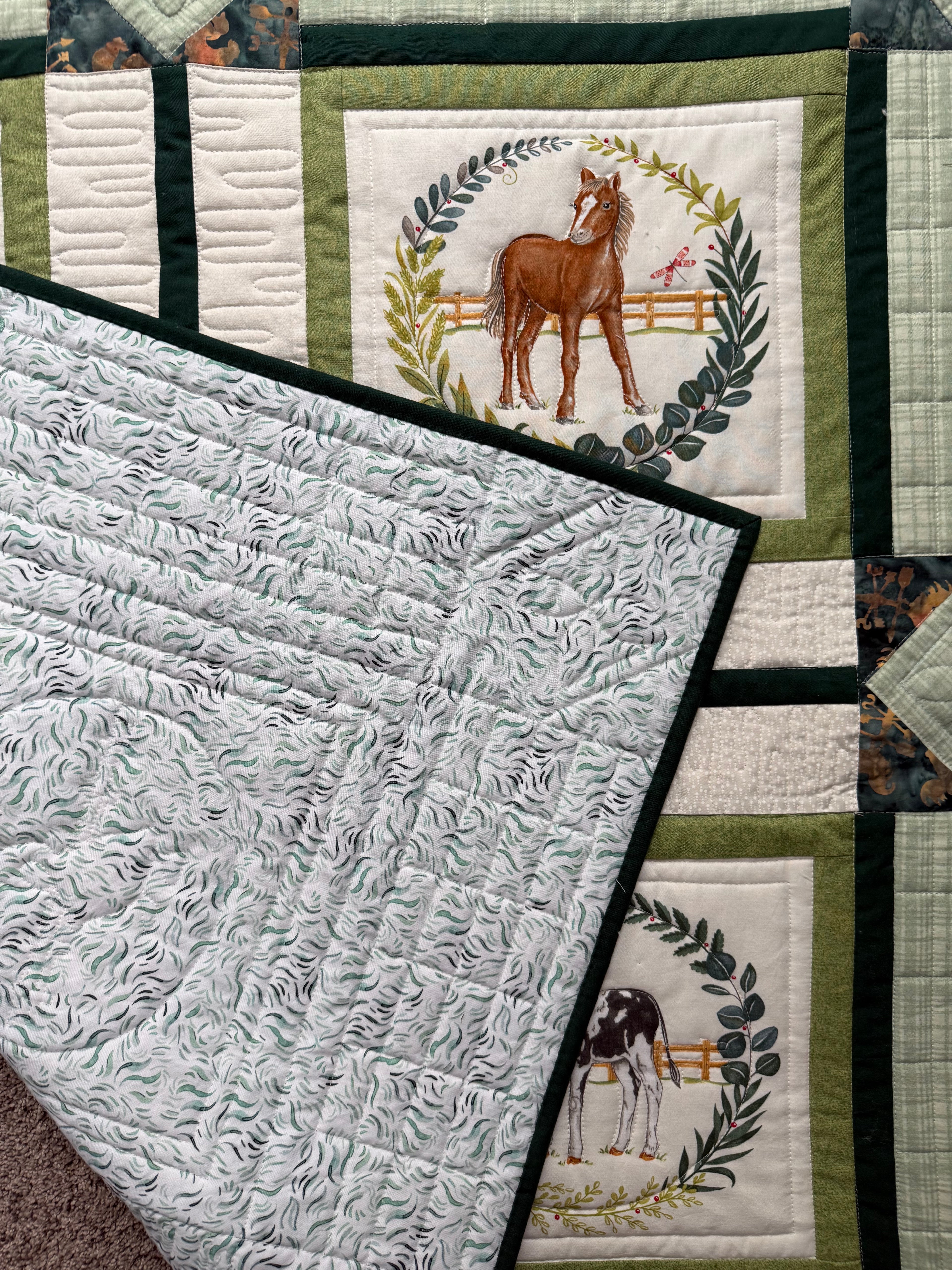 Baby farm animal quilt showing green and blue print backing