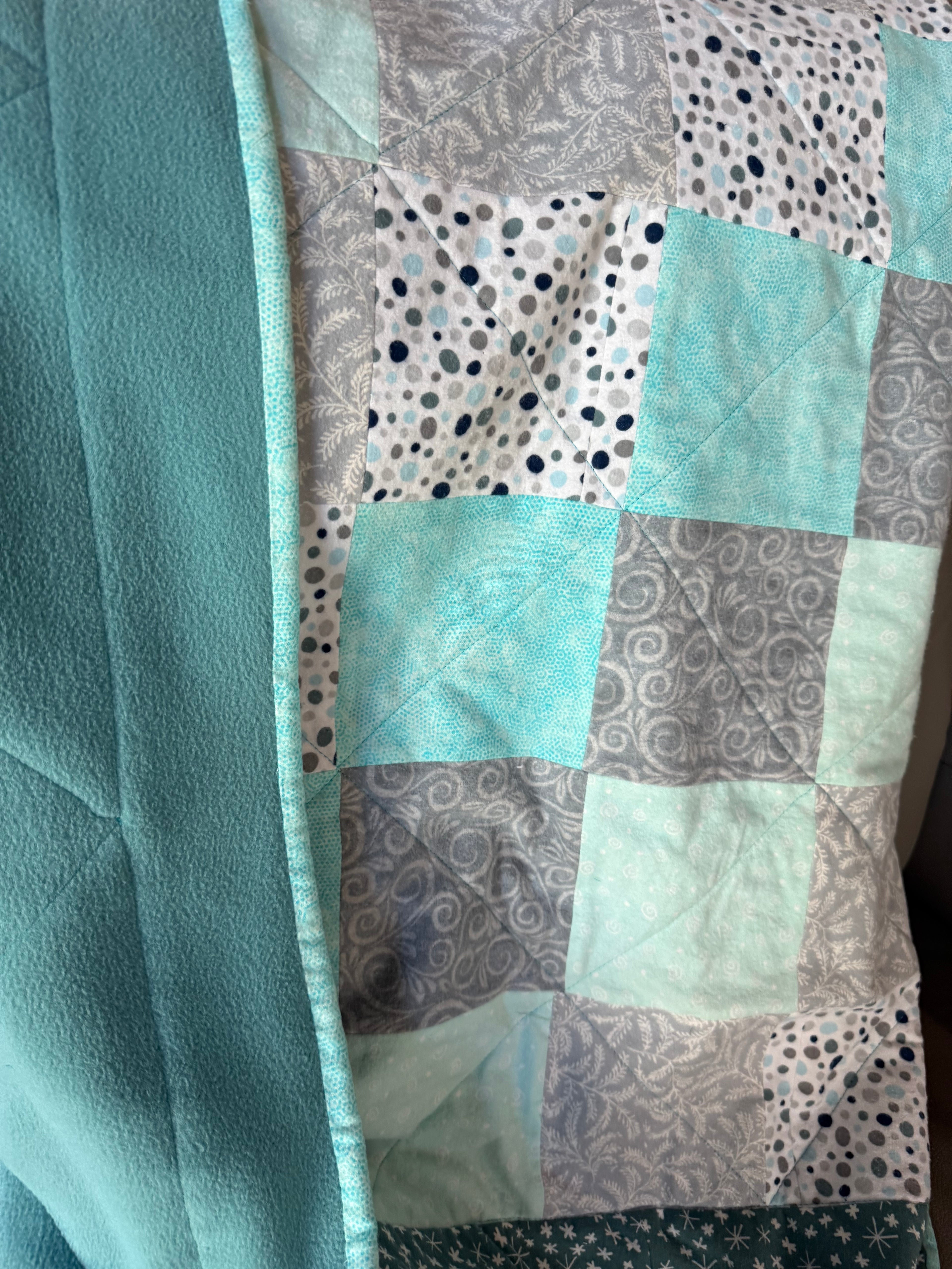 Handmade flannel scrap quilt in mixed prints, cozy and colorful, by Oak & Thread Quilts.  Backing is soft turquoise fleece