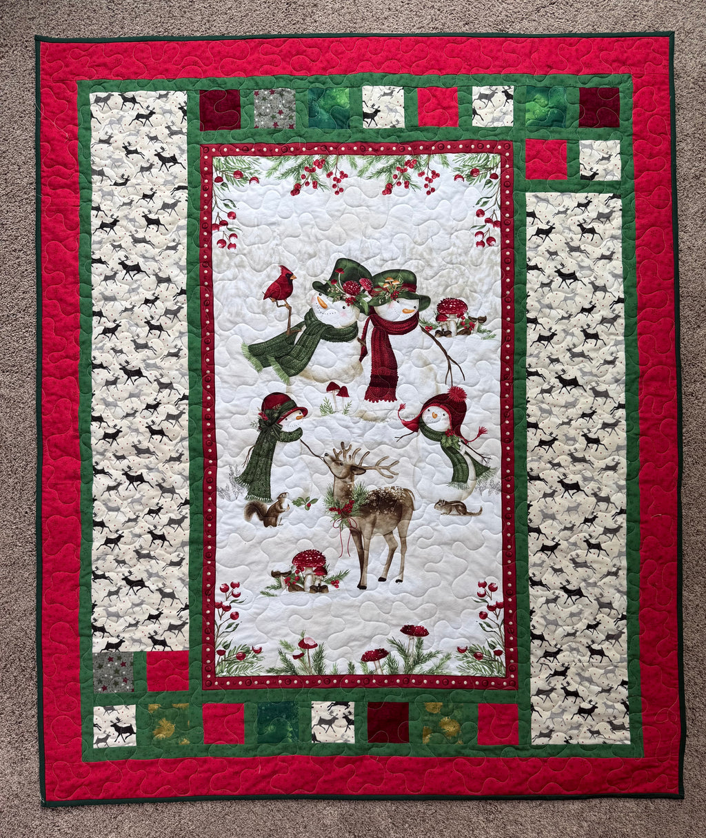 Handmade winter quilt featuring snowmen and forest animals