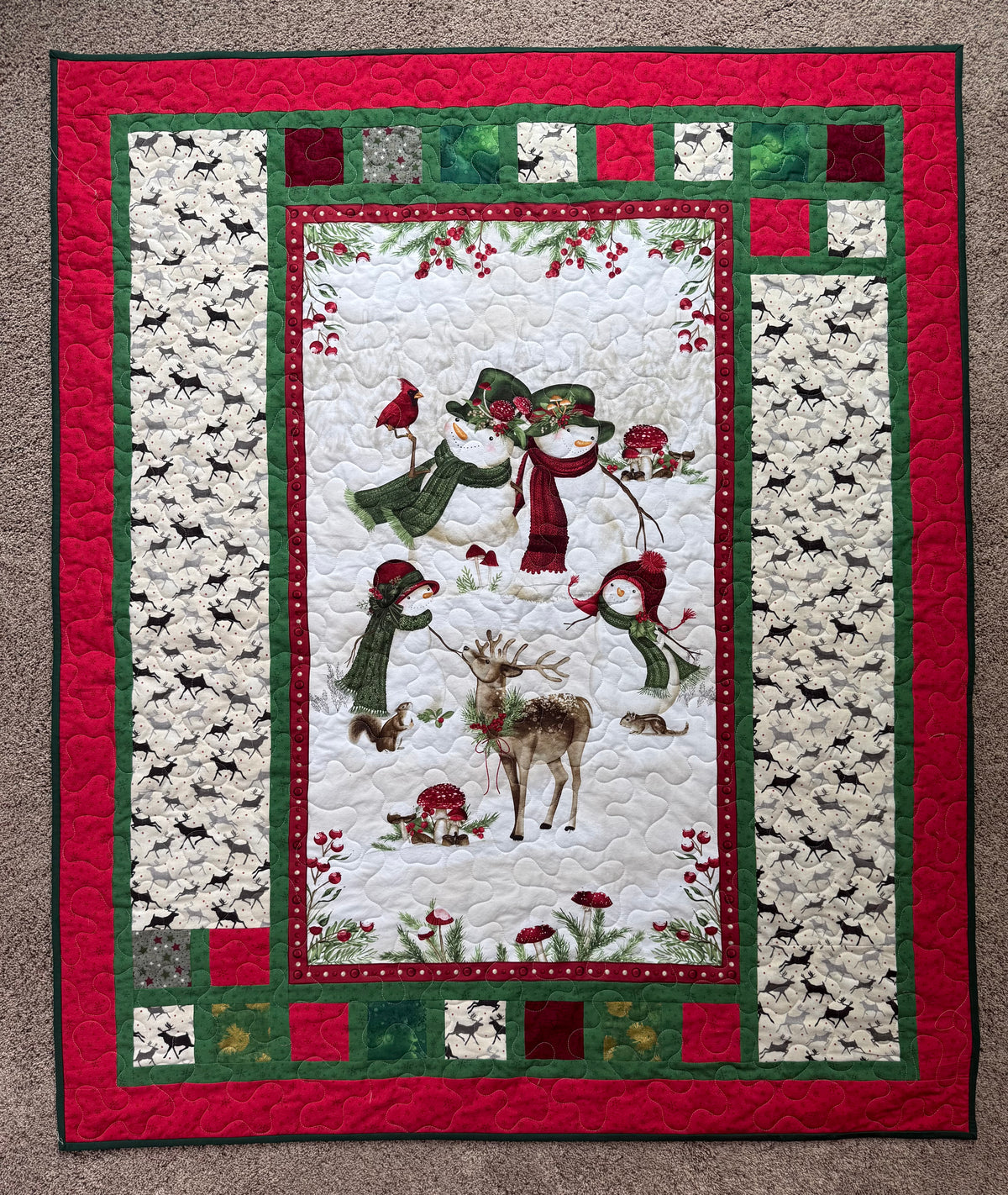 Handmade winter quilt featuring snowmen and forest animals