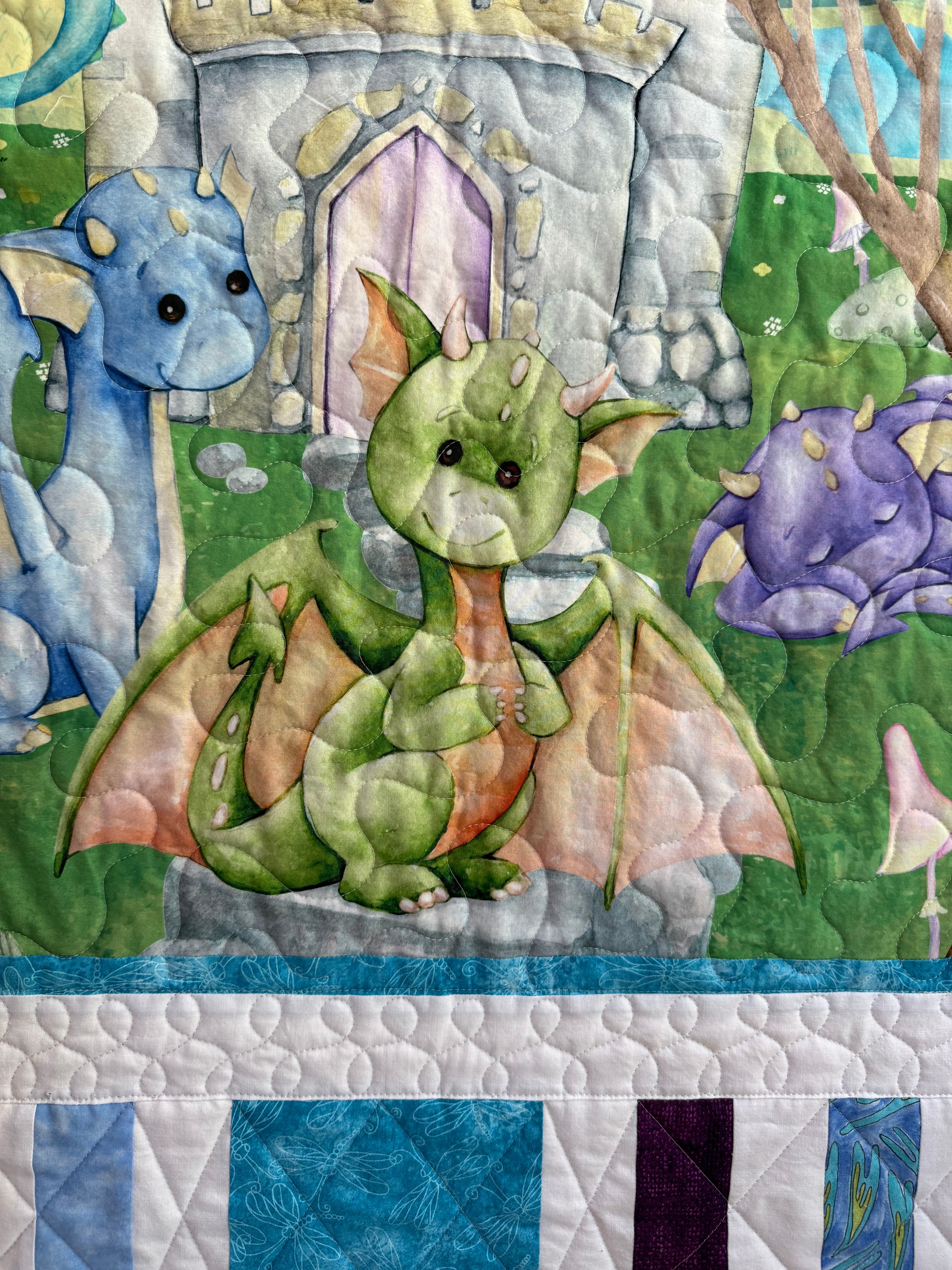 Handmade baby dragon quilt with colorful dragon design, soft cotton fabric, made by Oak & Thread Quilts