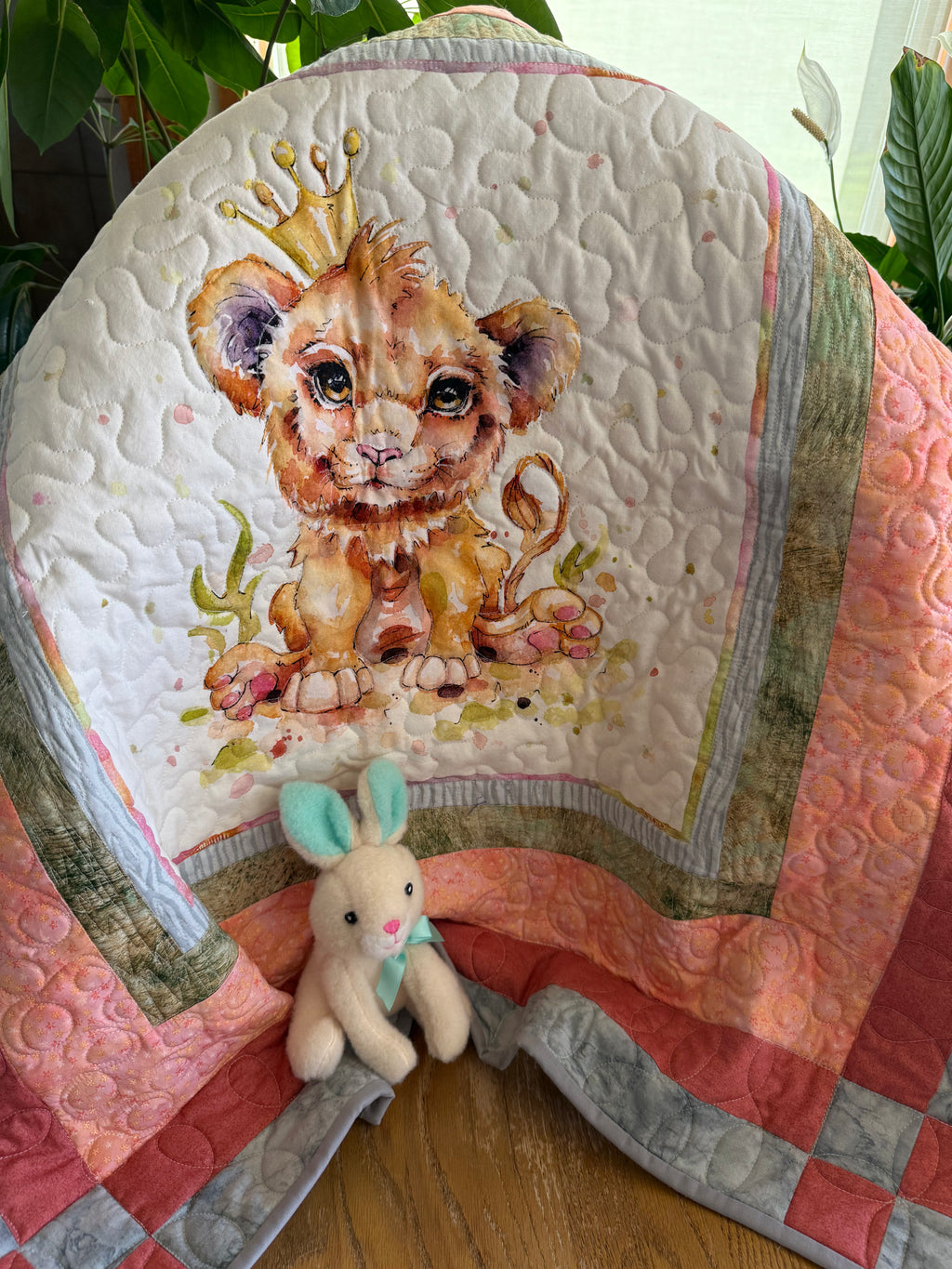 Handmade baby quilt with a lion in orange, red and gray.
