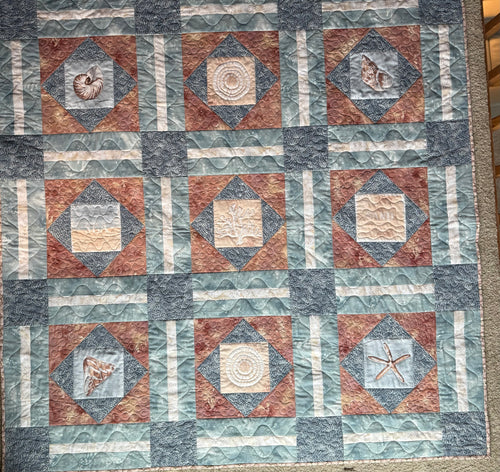 Handmade ocean theme quilt in soft blues and sand colors with ocean images