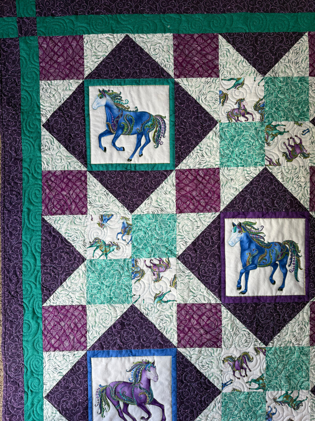 Handmade horse quilt in jewel tone cotton fabric featuring colorful horses with metallic highlights.