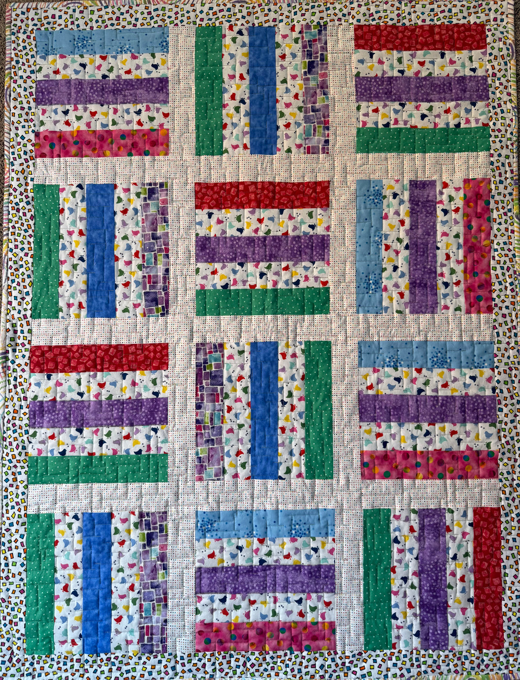 Handmade baby quilt in primary colors