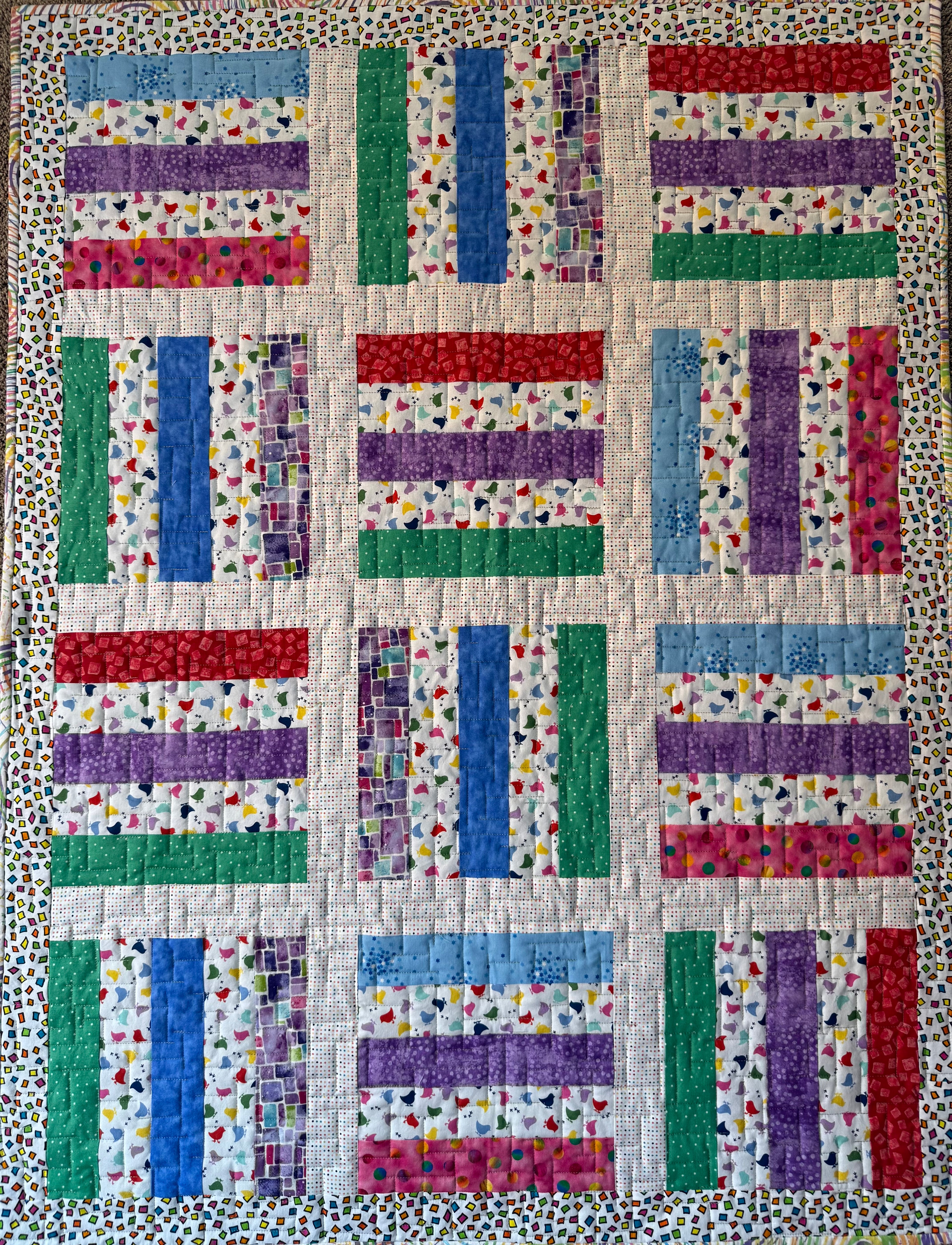 Handmade baby quilt in primary colors