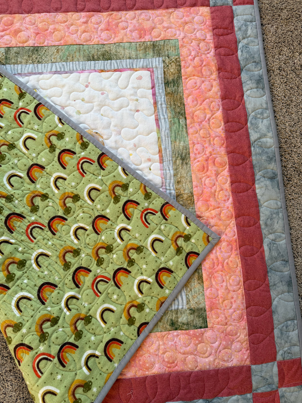 Handmade lion baby quilt showing green rainbow flannel backing fabric 