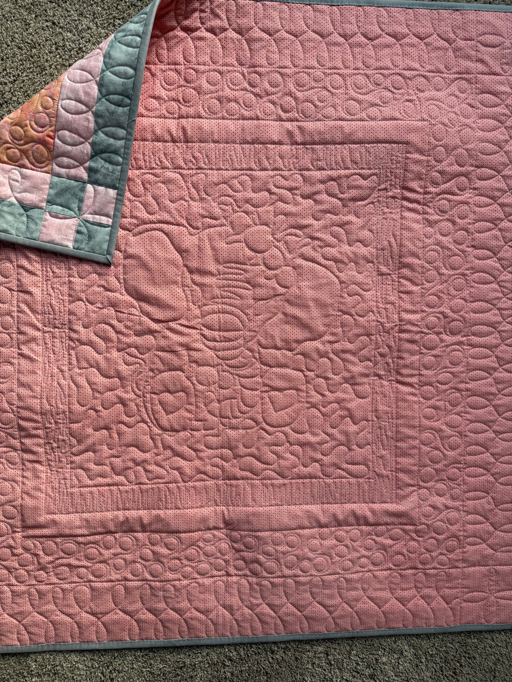 Pink backing of handmade elephant quilt showing quilting 