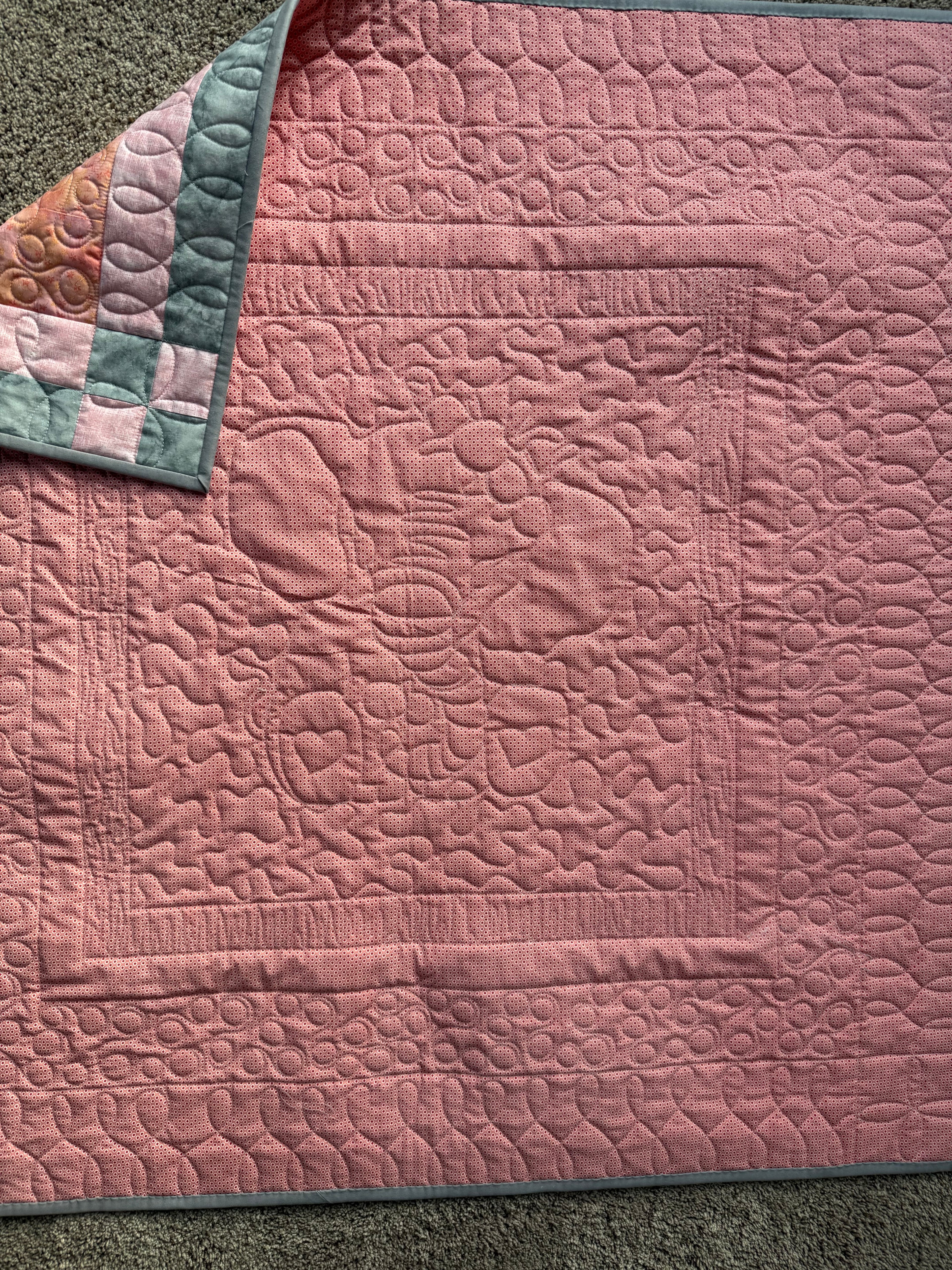 Pink backing of handmade elephant quilt showing quilting 