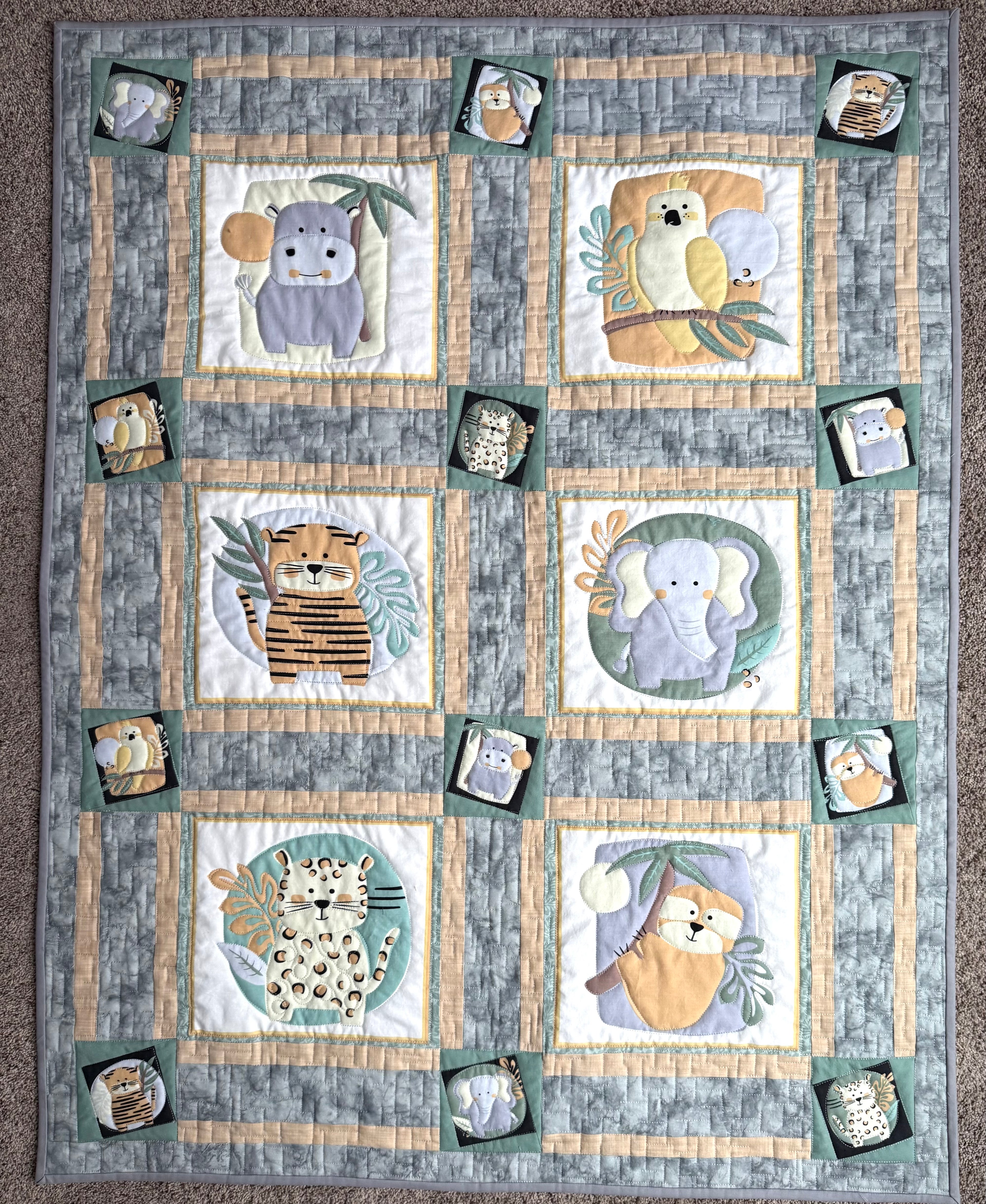 Handmade safari baby quilt with various animals in gray and sage green 