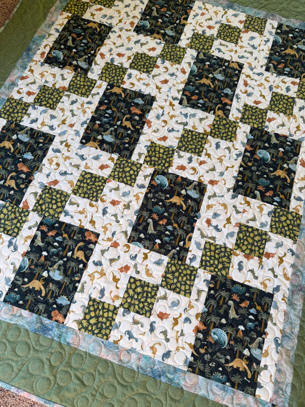 Handmade dinosaur quilt in blues and greens