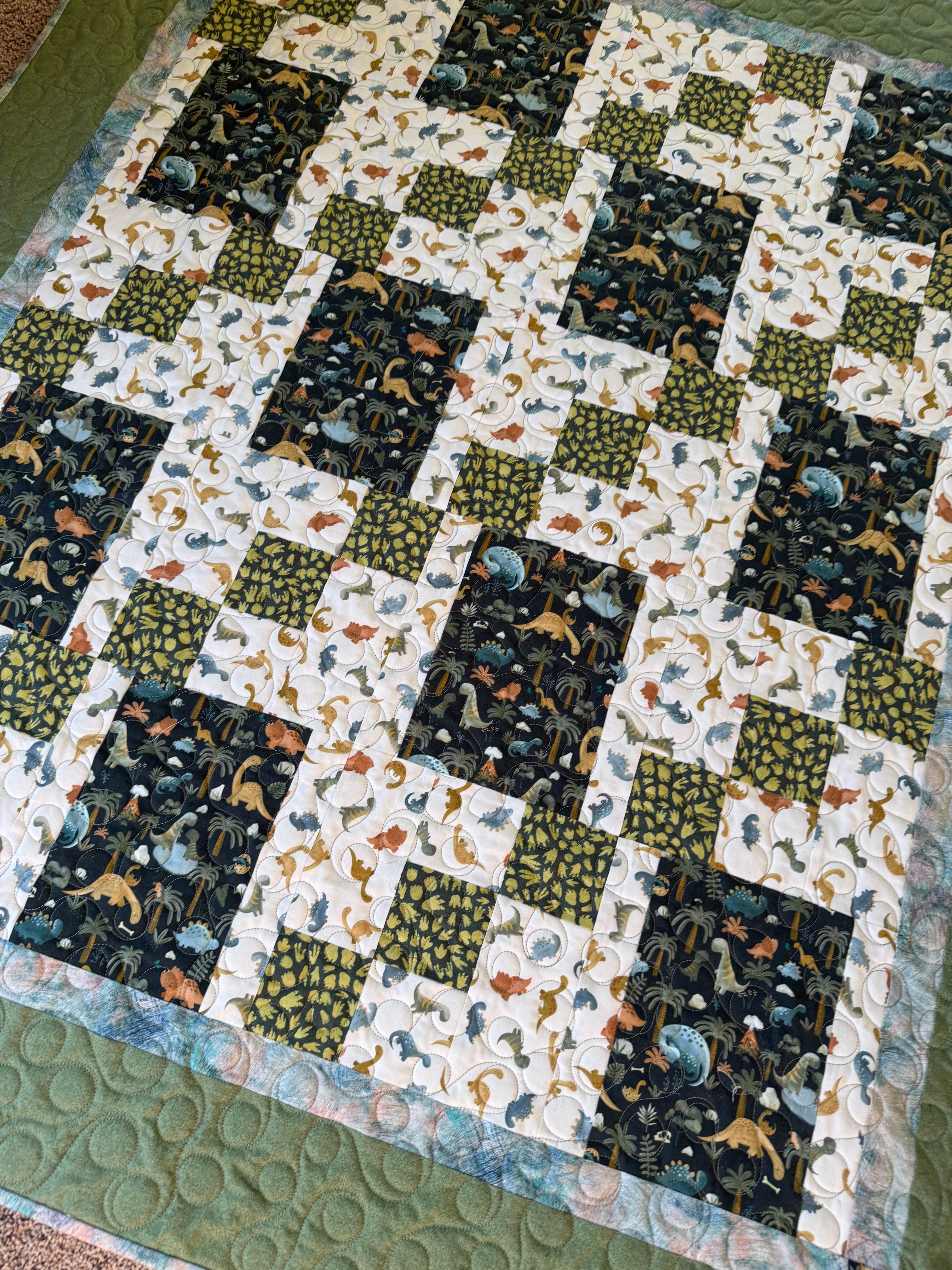 Handmade dinosaur quilt in blues and greens