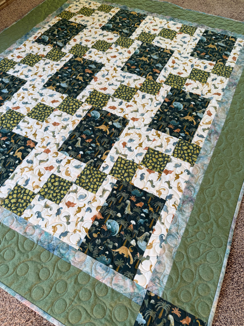Handmade dinosaur quilt with dinosaur fabric and green borders